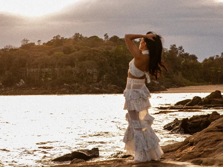 Saddy on the rocks at sunset, hands in her hair