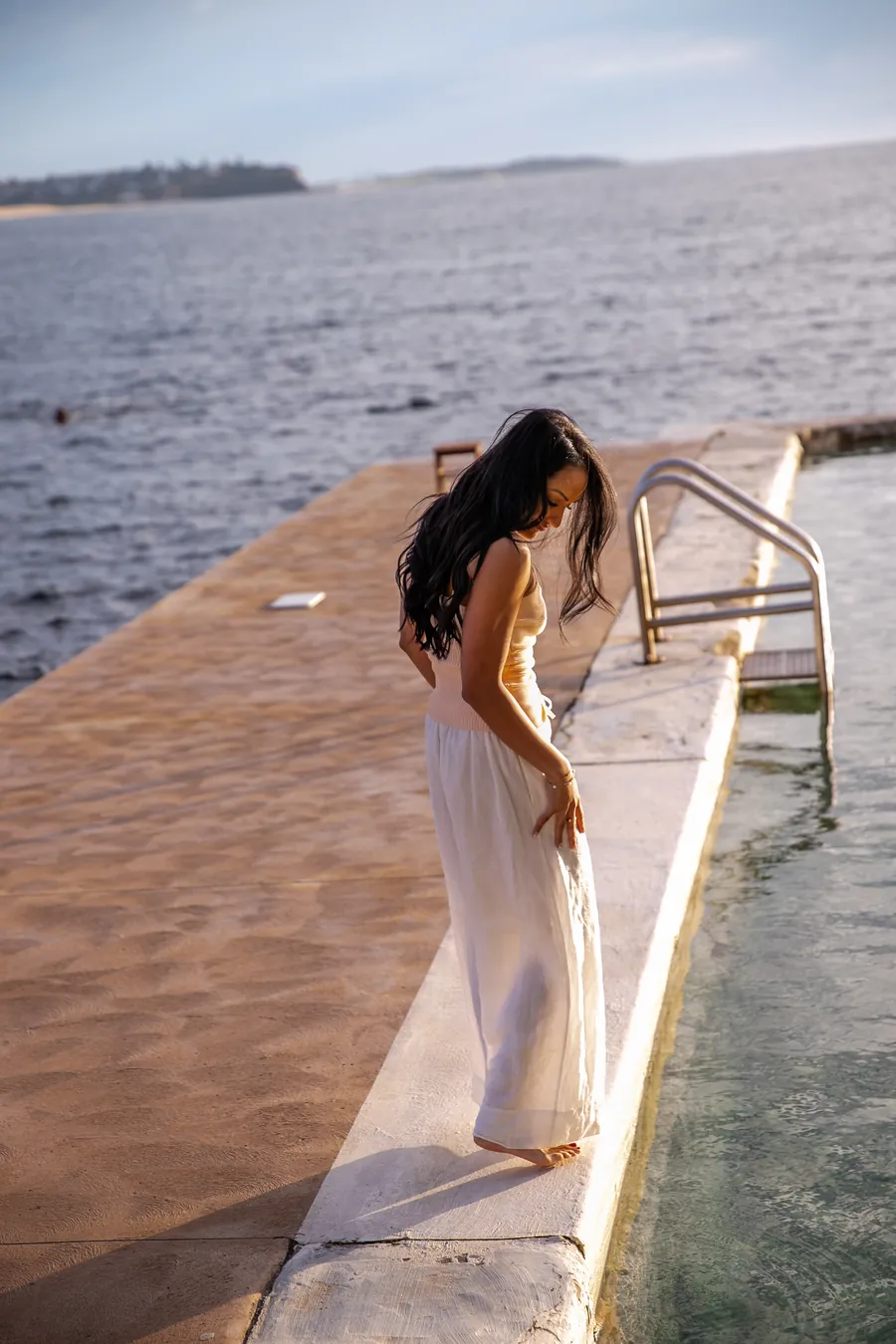 Saddy walking along a jetty by the water