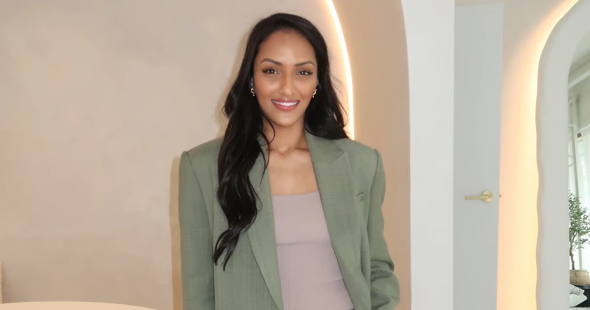 Saddy smiling in the arched room, sage blazer