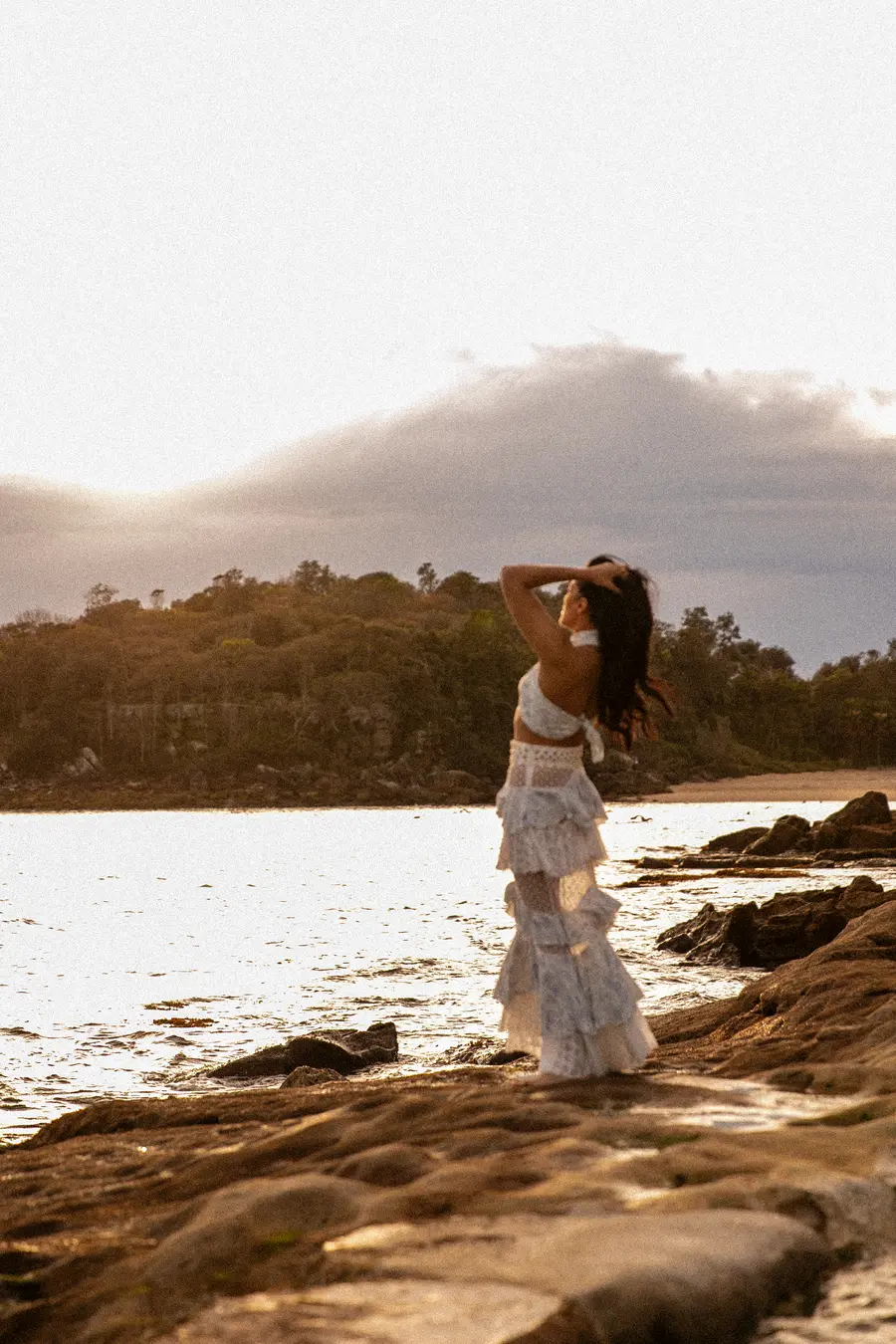 Saddy on the rocks at sunset, hands in her hair