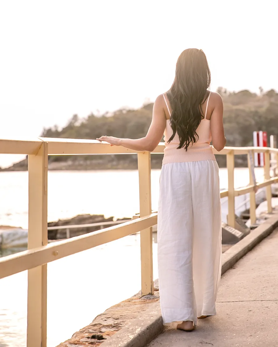 Saddy from behind, one hand on the railing, looking out over the water