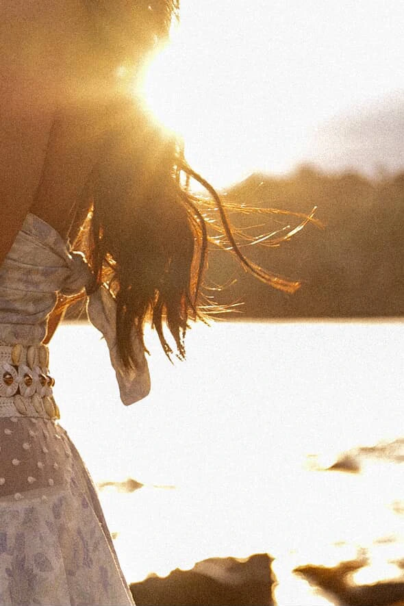 Saddy's hair lit by the setting sun, by the water