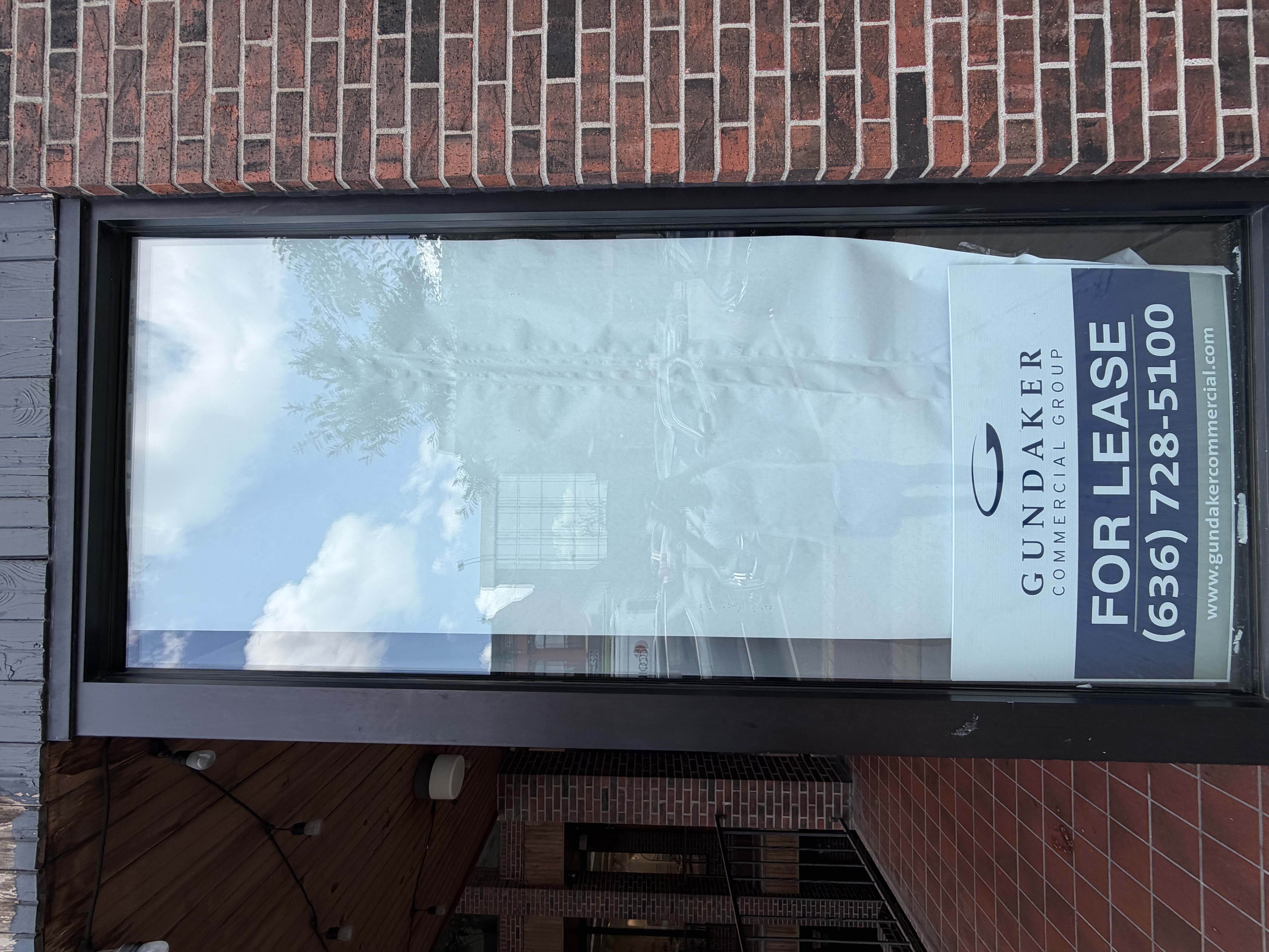 A commercial storefront with a large glass window on a brick building.