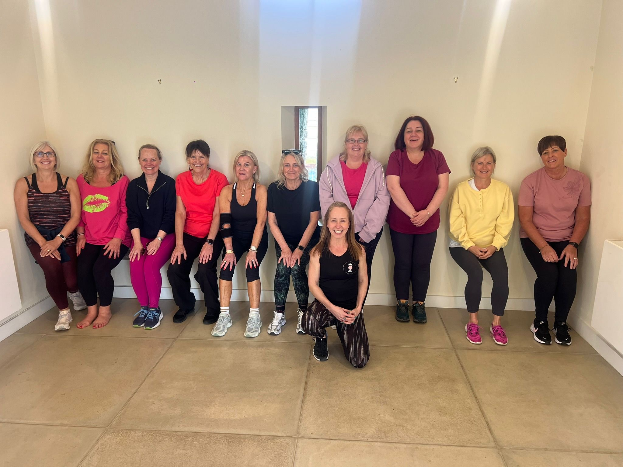 The women of the Belle Vitale Wellness April retreat, wall-sitting together