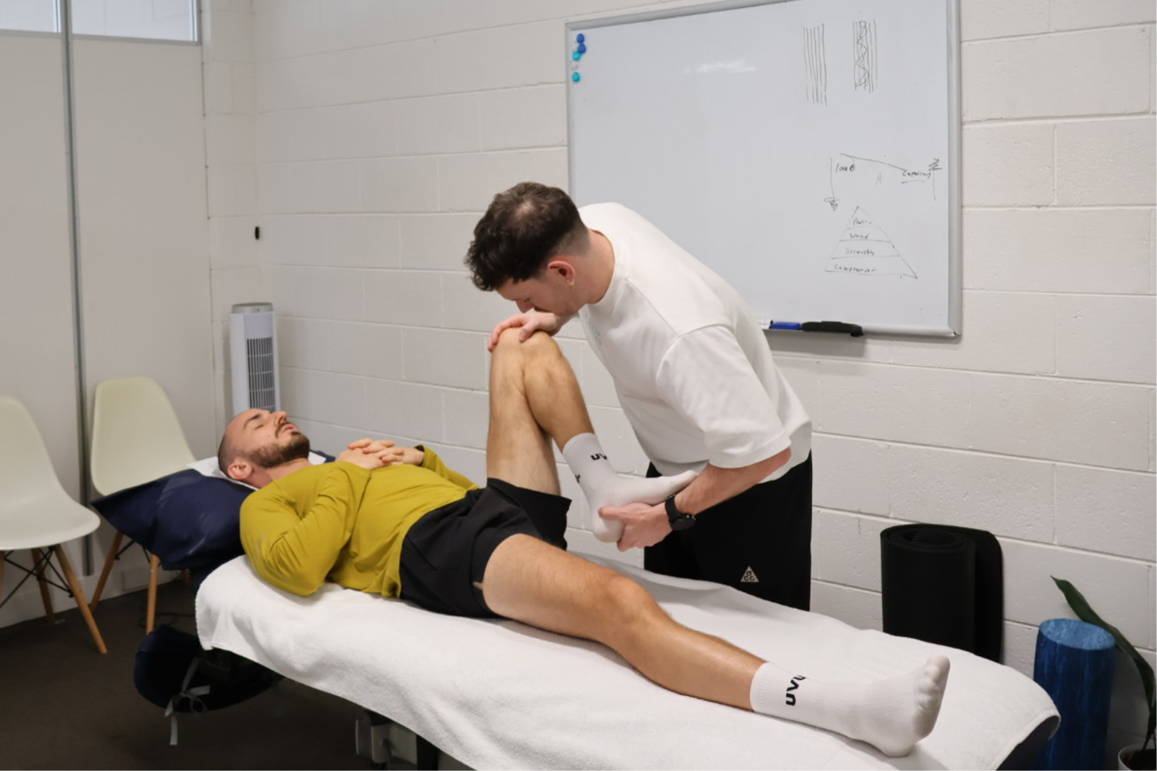 Clinician discussing history and reviewing a running injury with a patient