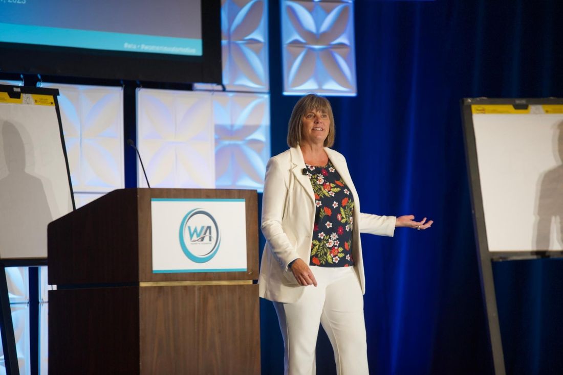Jodee O'Brien speaking at a conference podium