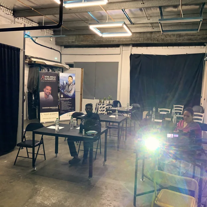Set build with staging, chairs and a lighting rig in a darkened room