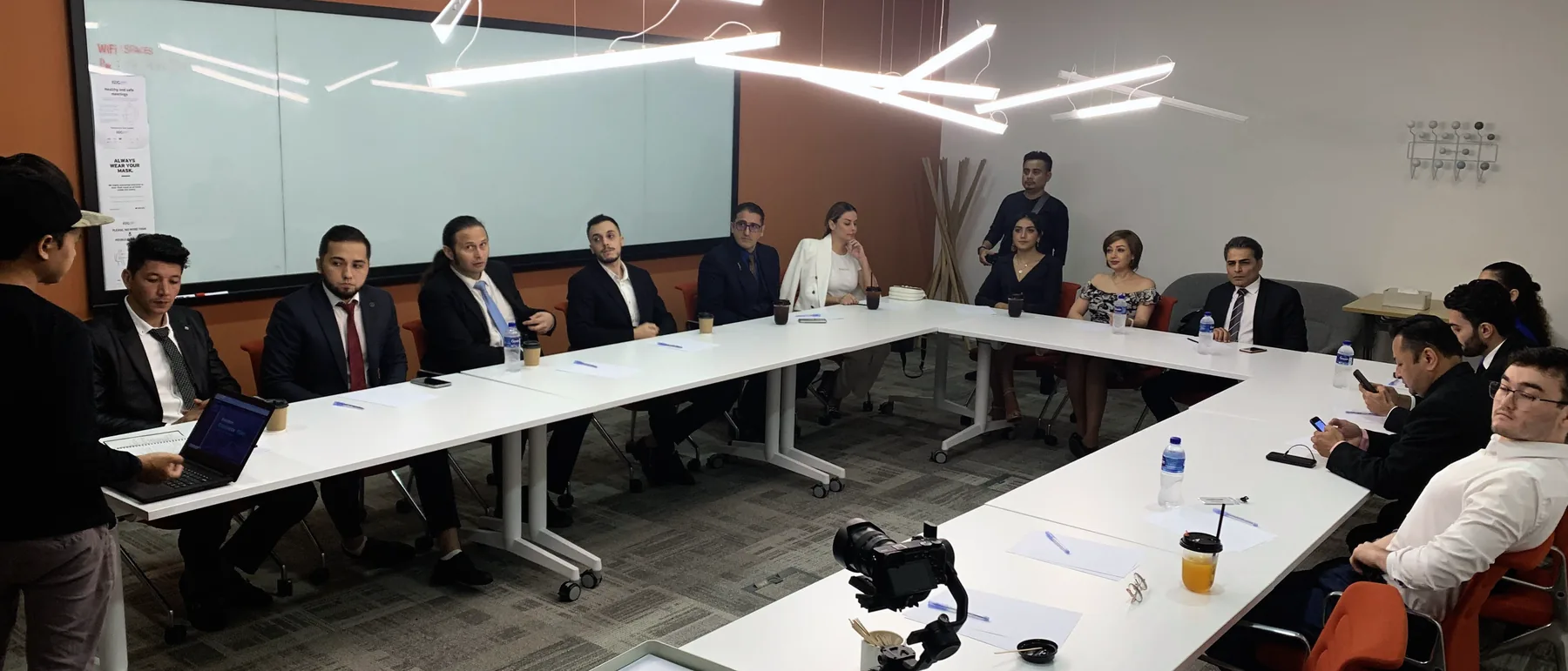Boardroom session filmed on location, long table with the client team and a camera on a tripod