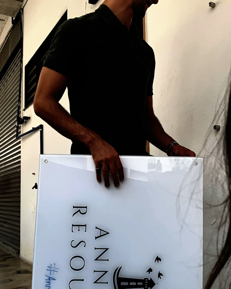 The Annaba Resources sign being carried into the new studio space in December 2022