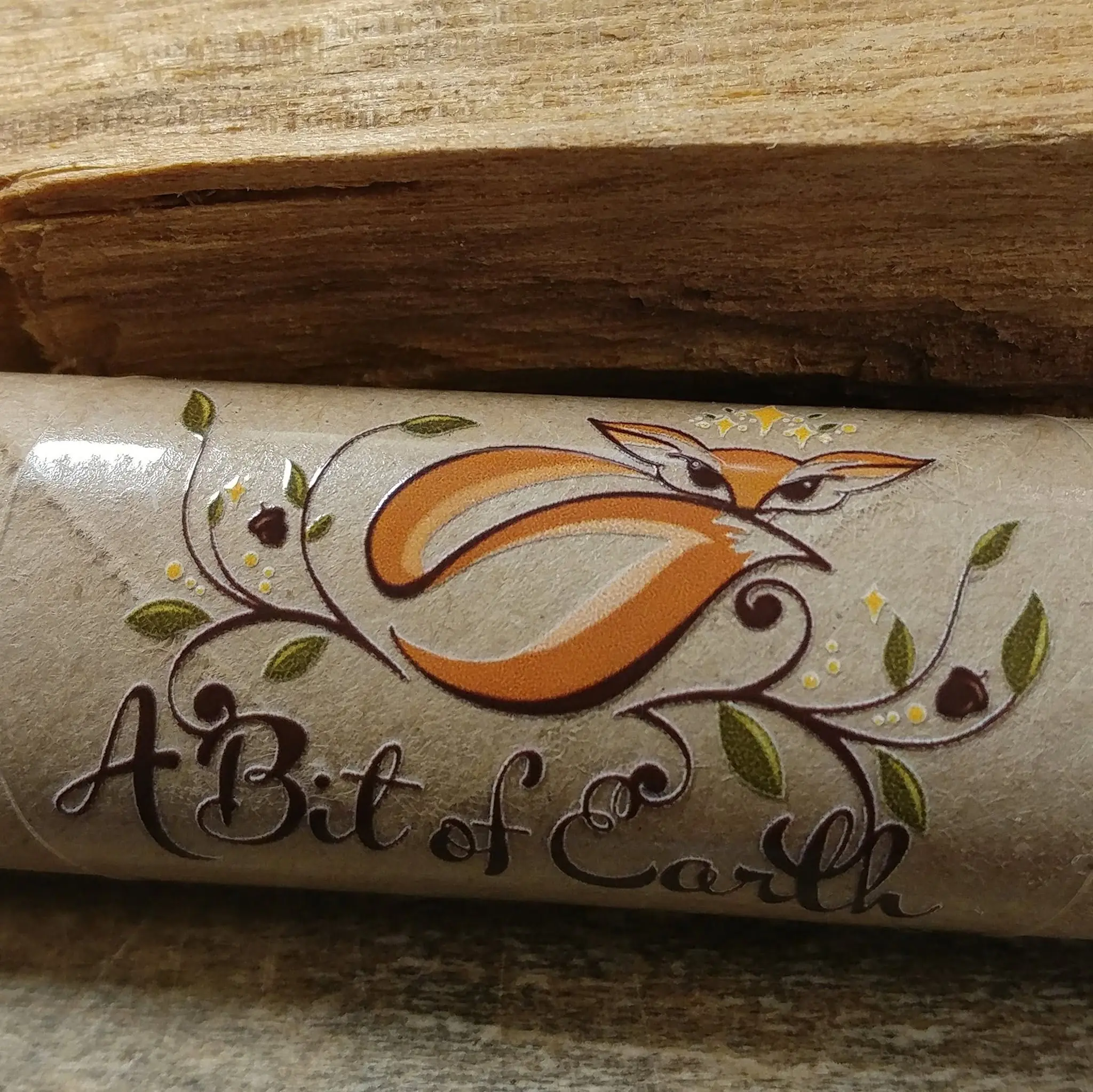 A Bit of Earth logo on a kraft paper tube