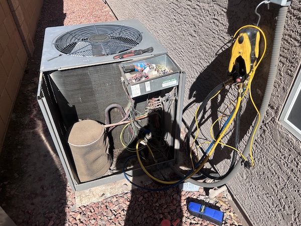 Emergency AC diagnostic with gauges on an open condenser by Rush HVAC Services in the East Valley, AZ