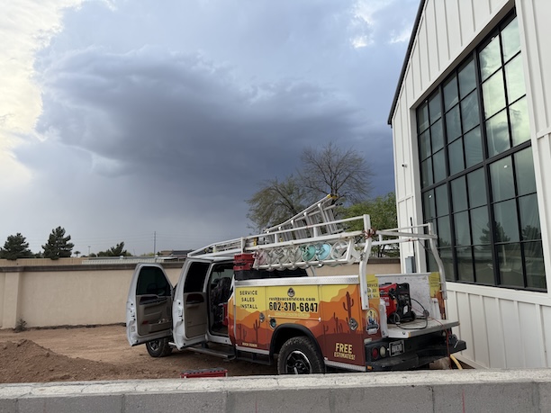 Rush HVAC Services service truck at an Apache Junction, AZ job site as monsoon storm clouds build over the East Valley