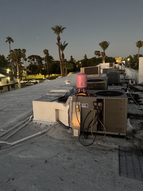 Refrigerant gauges connected to a rooftop AC unit during a Rush HVAC Services repair in Chandler, AZ