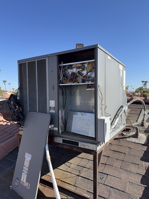 Rooftop package unit with the access panel open during a Rush HVAC Services repair at a Queen Creek, AZ home