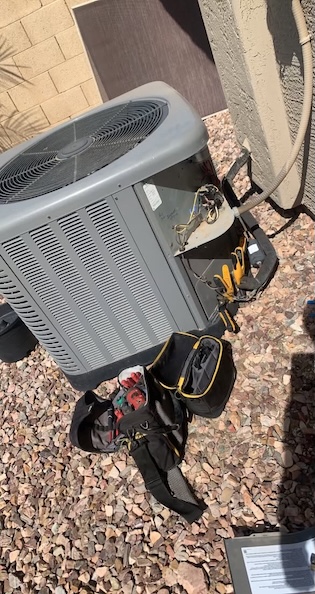 Rush HVAC Services technician tools beside an open AC condenser service panel during a diagnostic in Gold Canyon, AZ
