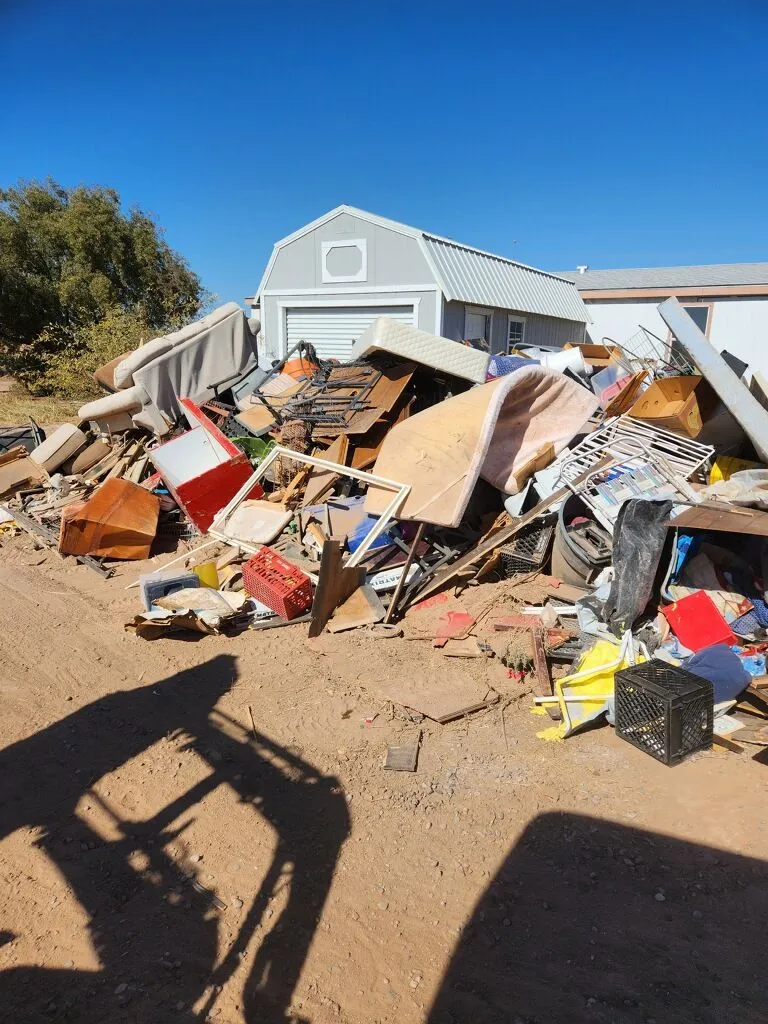 Large mixed debris pile beside a building, ready for A1 to load and haul away.