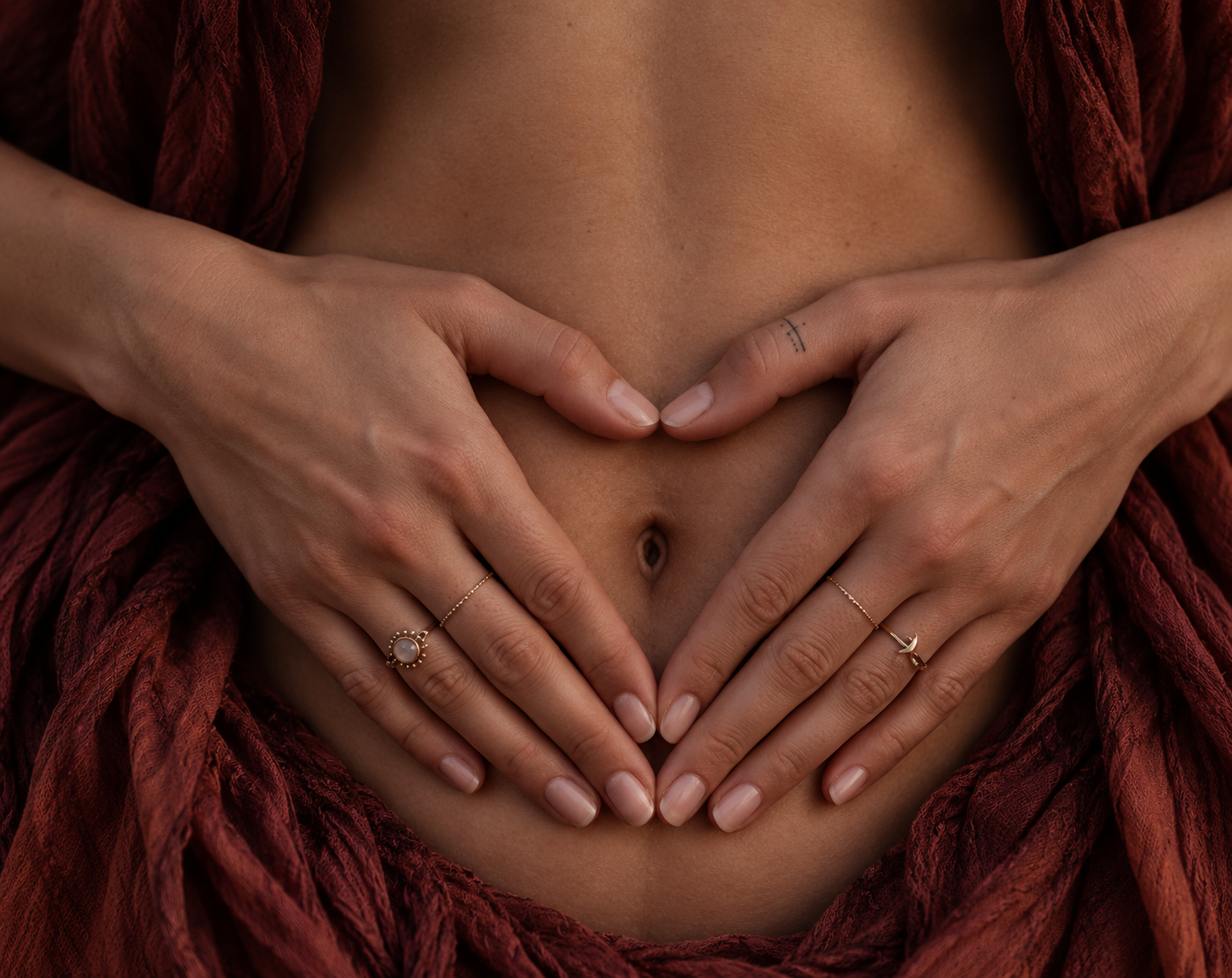 Hands resting over the womb in a heart shape