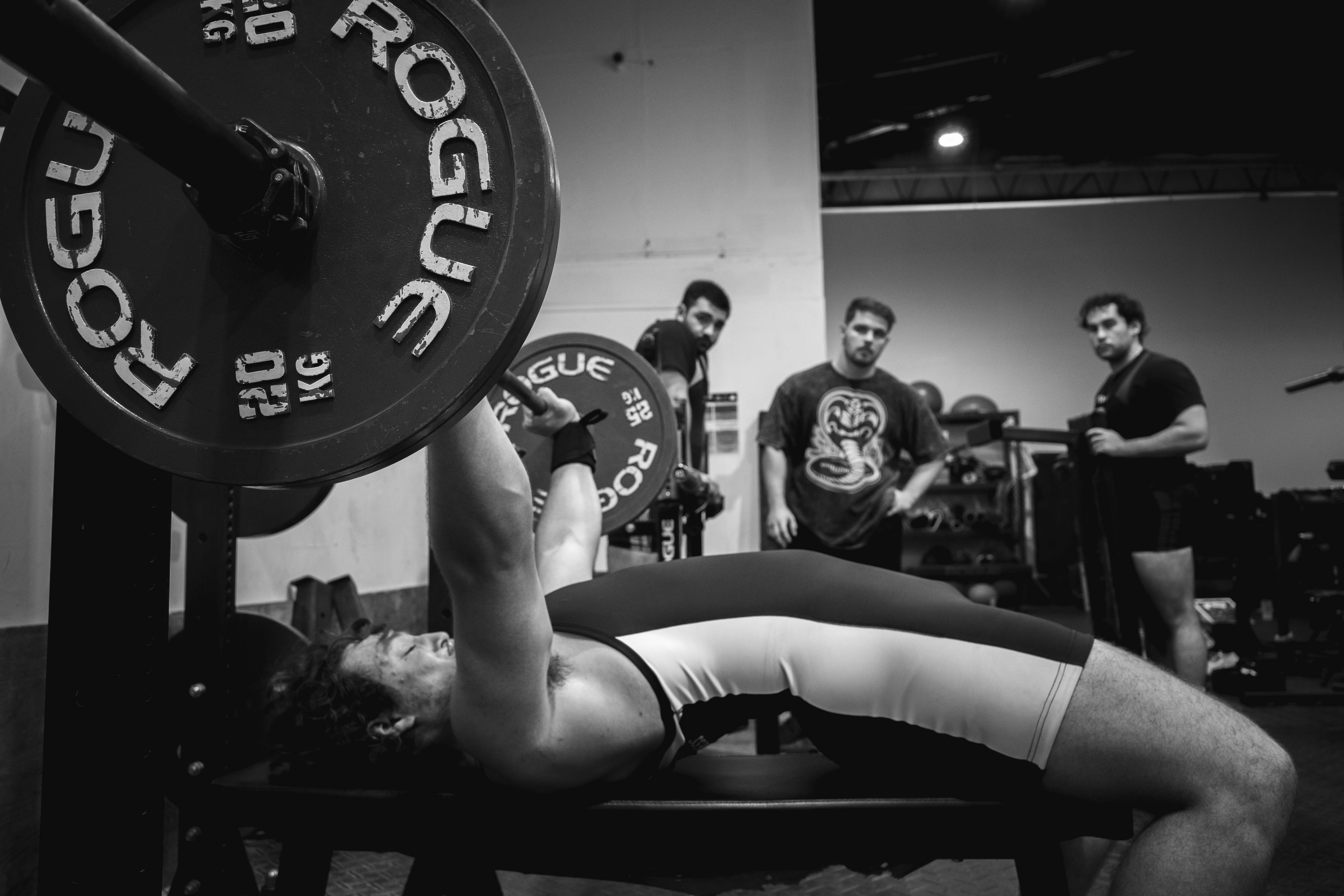 Team Soul members performing barbell strength training during a powerlifting session in Miami.  Powerlifting athletes training the squat, bench press, and deadlift at Team Soul Fort Lauderdale.