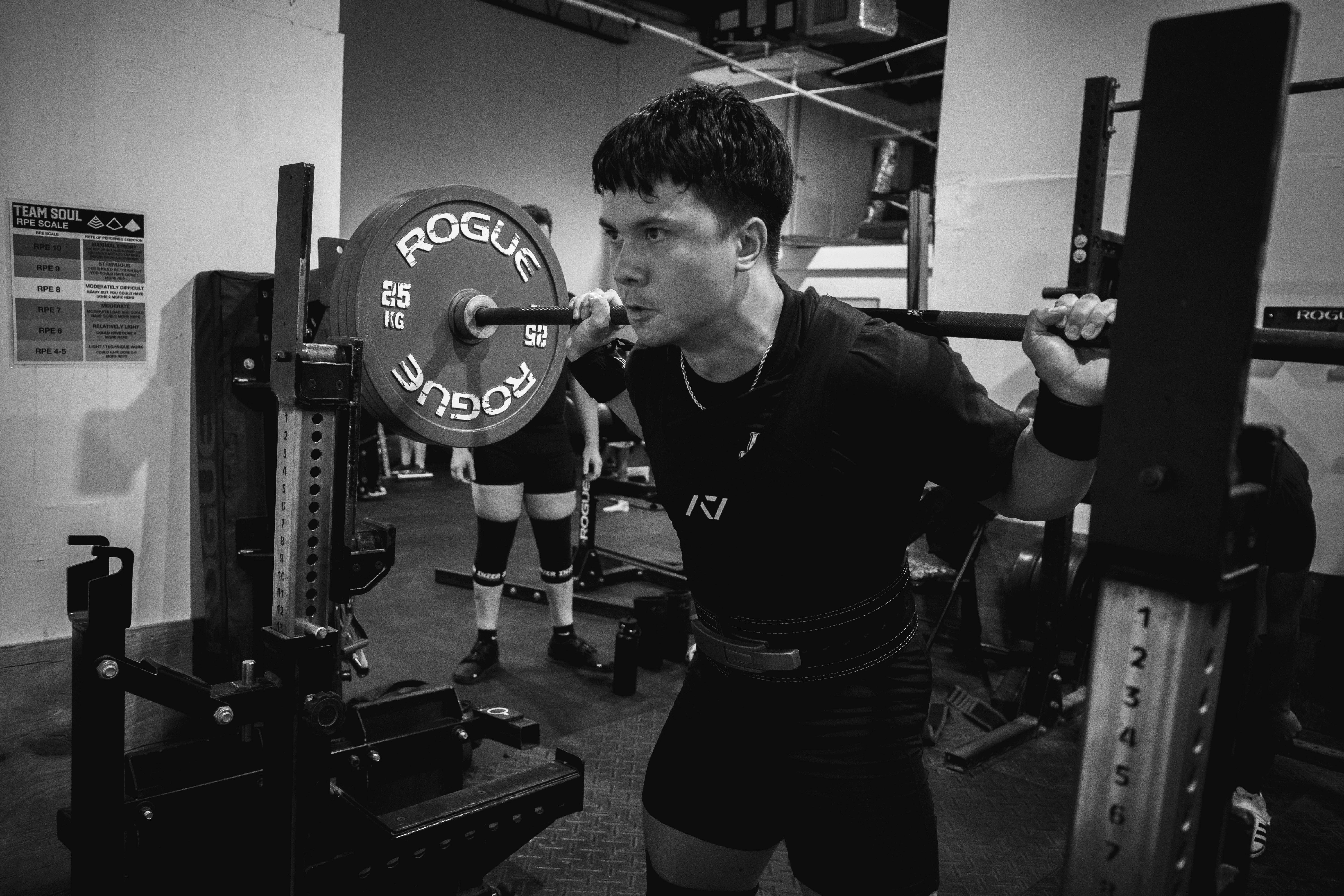 Team Soul members performing barbell strength training during a powerlifting session in Miami.  Powerlifting athletes training the squat, bench press, and deadlift at Team Soul Fort Lauderdale.