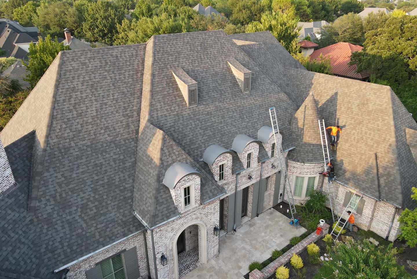 Roofing professionals working on a home's roof