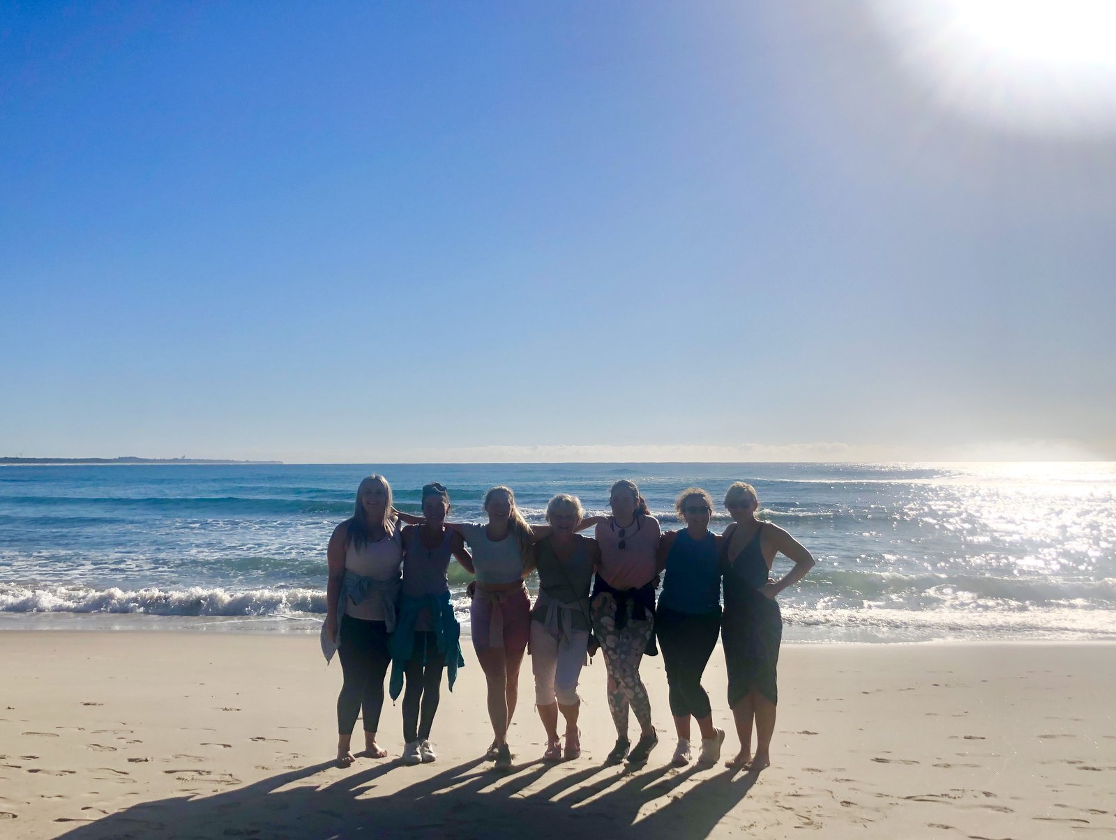 A group of women together on the beach on a sunny day