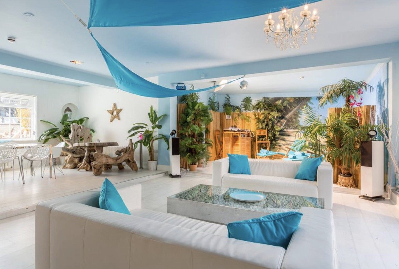 A bright daytime lounge with a tropical mural and driftwood furniture