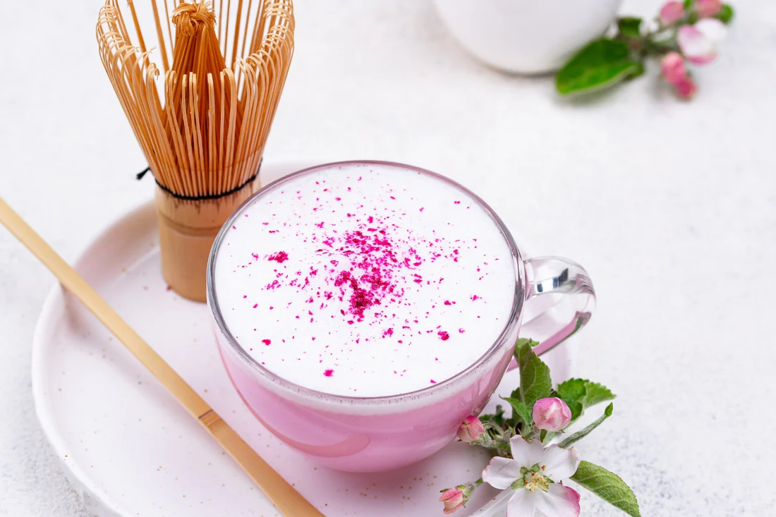 Pink rose latte from Loose Leaf Tea Market with bamboo matcha whisk and apple blossoms