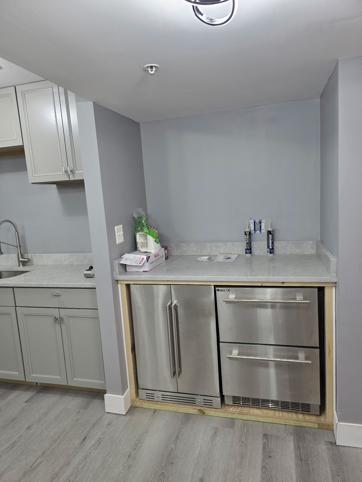 Basement kitchenette with beverage station in wellness remodel by Andre Horne