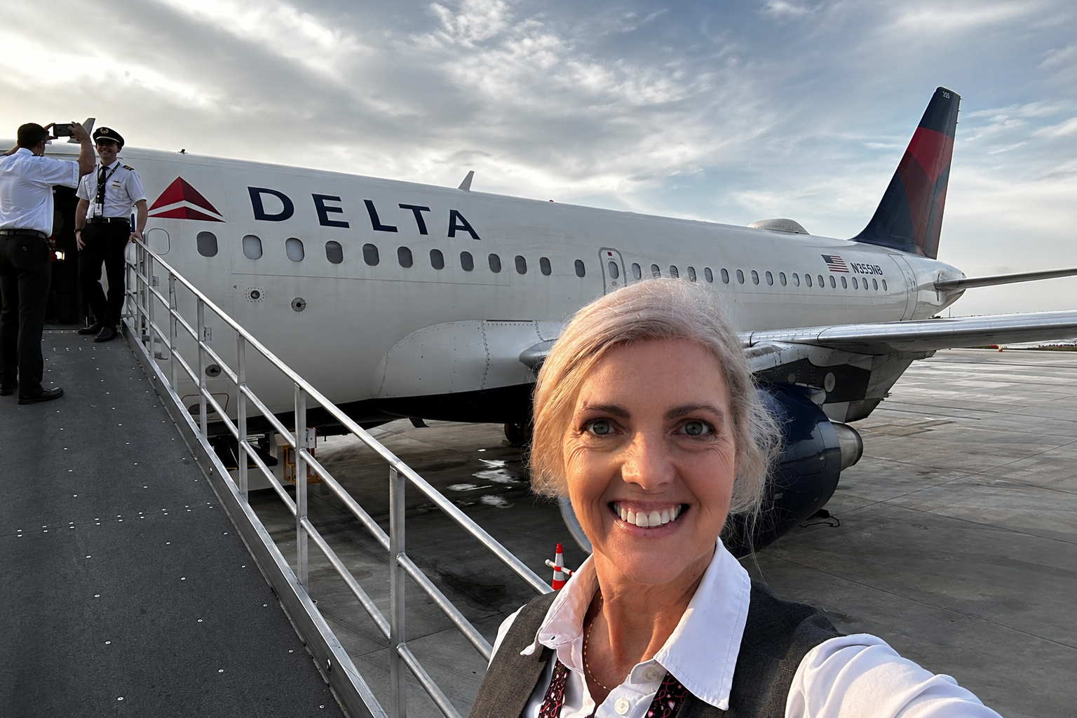 Elizabeth Garrison in flight attendant uniform beside a Delta aircraft after beginning a new career at 48. Elizabeth Garrison in flight attendant uniform beside a Delta aircraft after beginning a new career at 48.