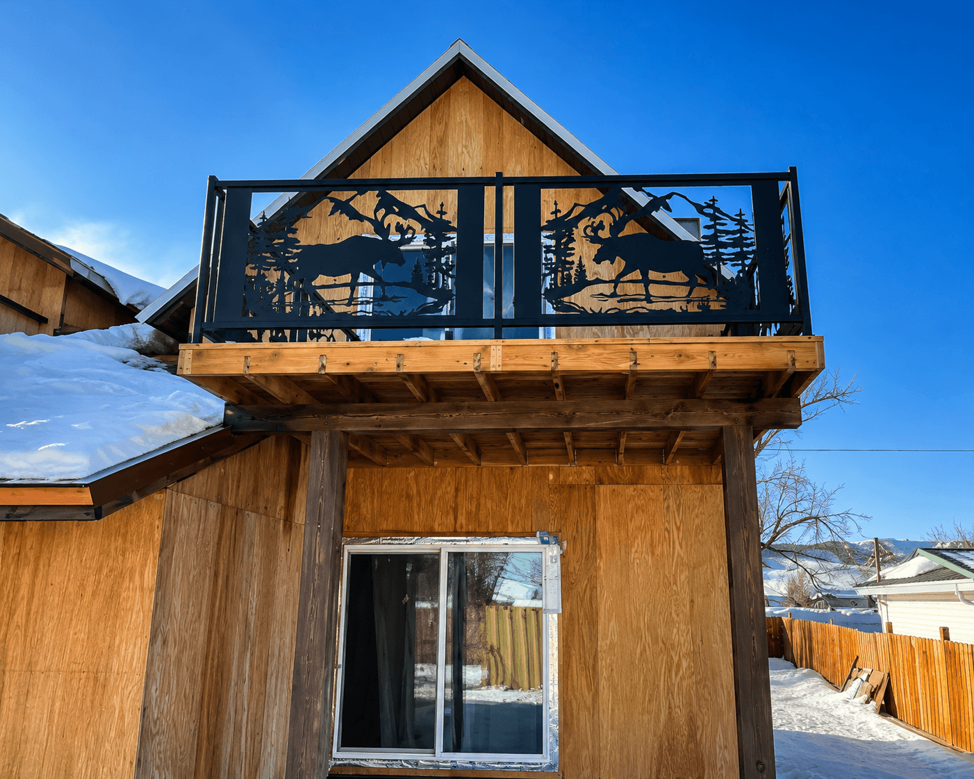 Custom iron cabin balcony railing with moose designs fabricated by Kodiak Gates & Iron.