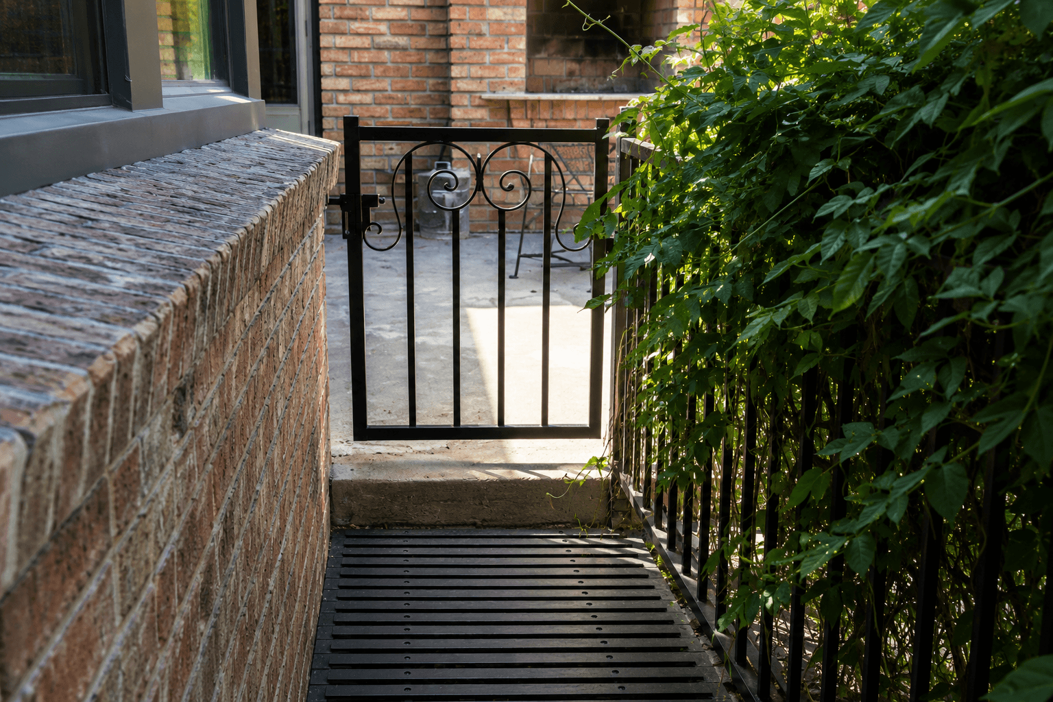 Ornamental custom dog access iron gate fabricated by Kodiak Gates & Iron.