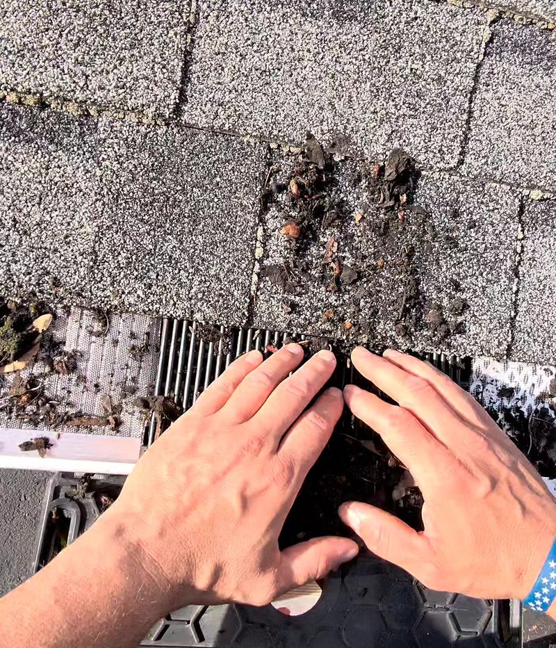 Shane pushing roof debris onto gutter guard samples during a side-by-side demo