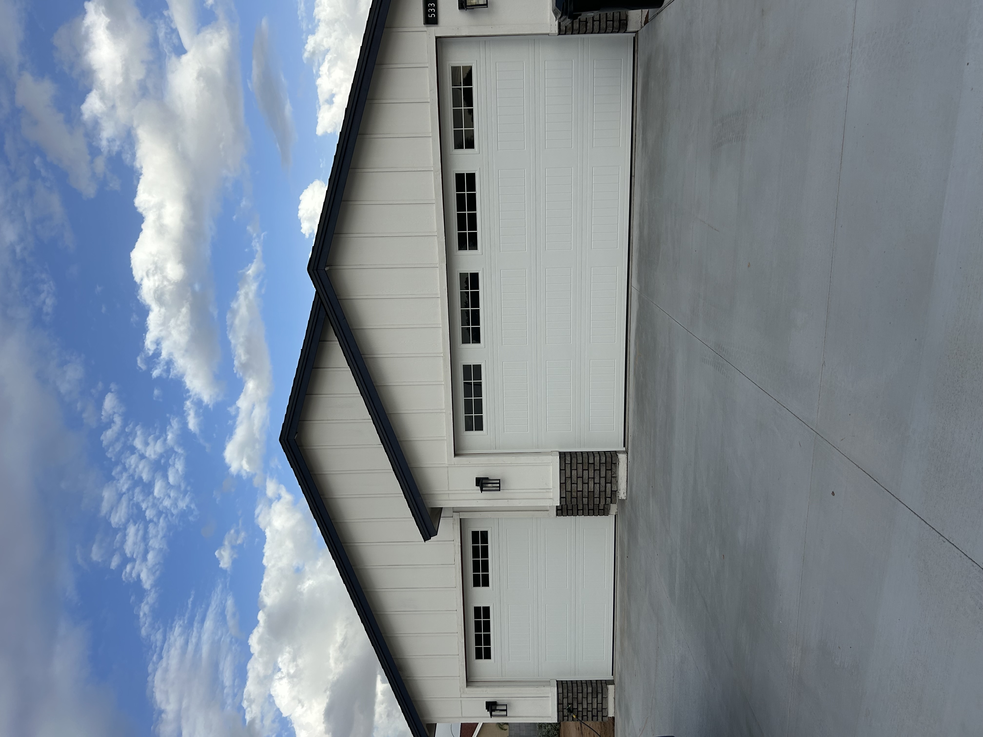 Residential garage door on a Mesa, Arizona stucco home with desert landscaping