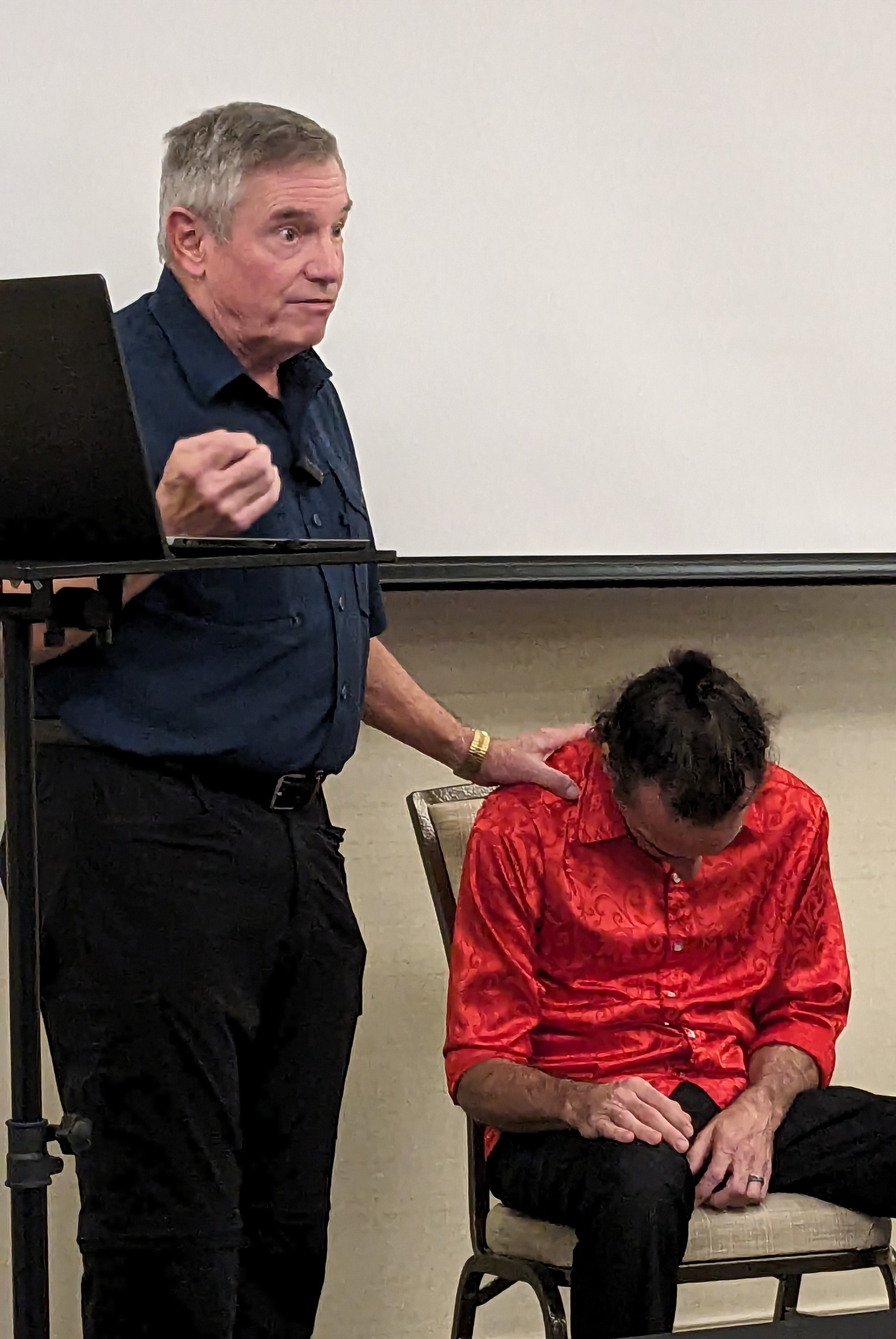 A hypnosis instructor working with a volunteer in front of a class