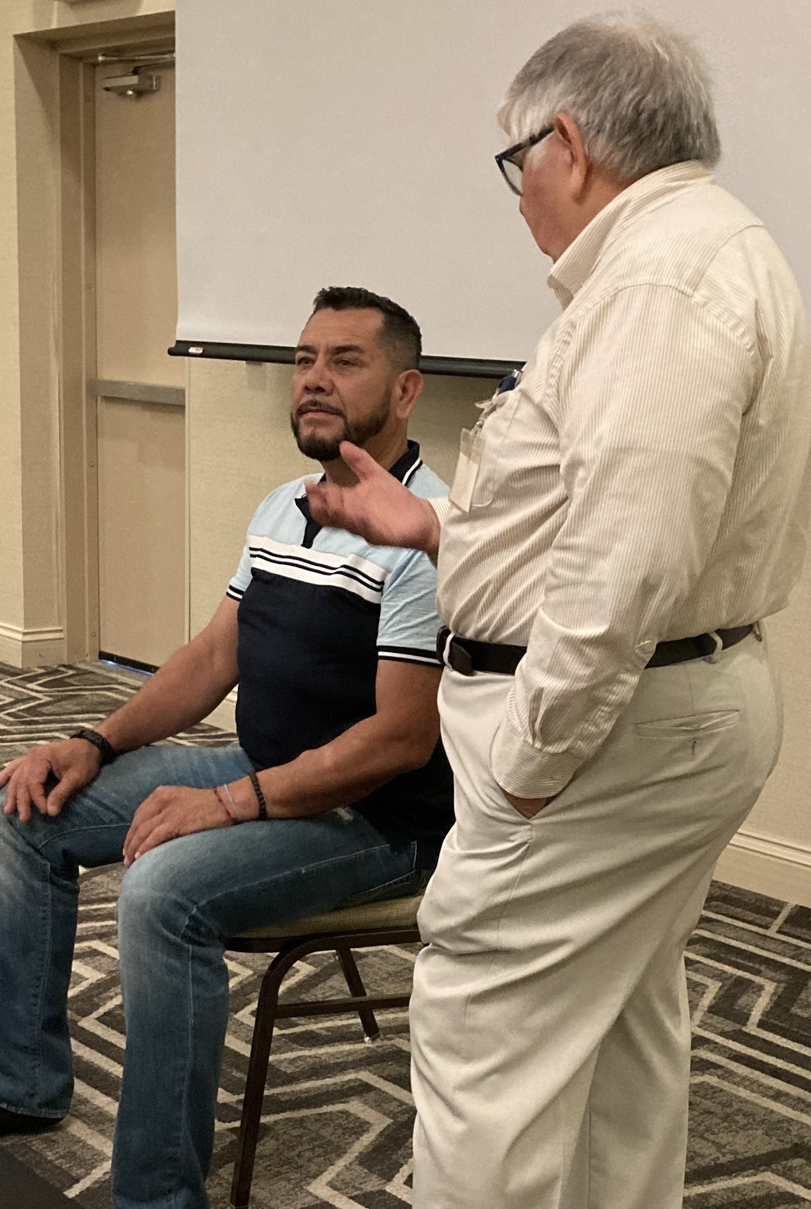 Students practicing hypnosis techniques in pairs during a training class