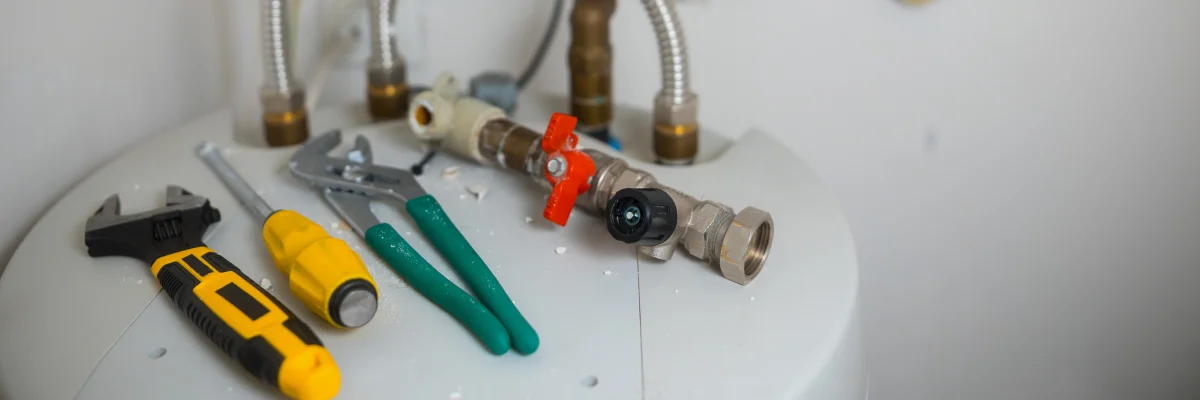 Plumbing tools and shutoff valve placed on residential water heater.
