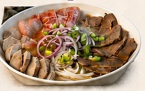A bowl of phở with sliced beef, rice noodles and fresh herbs