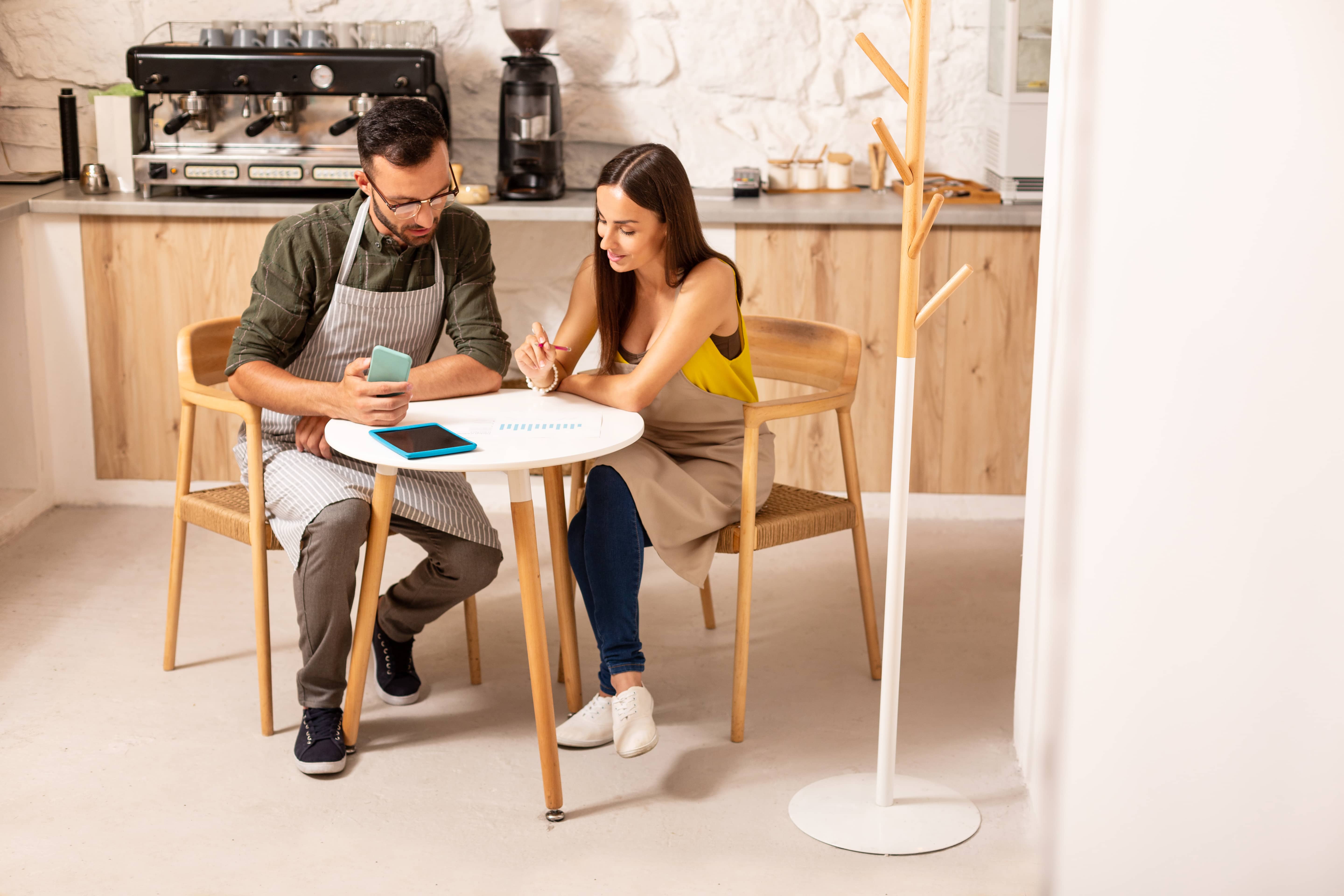 Café owners looking through and discussing finances