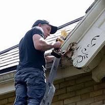 Technician sealing an entry point at the roofline