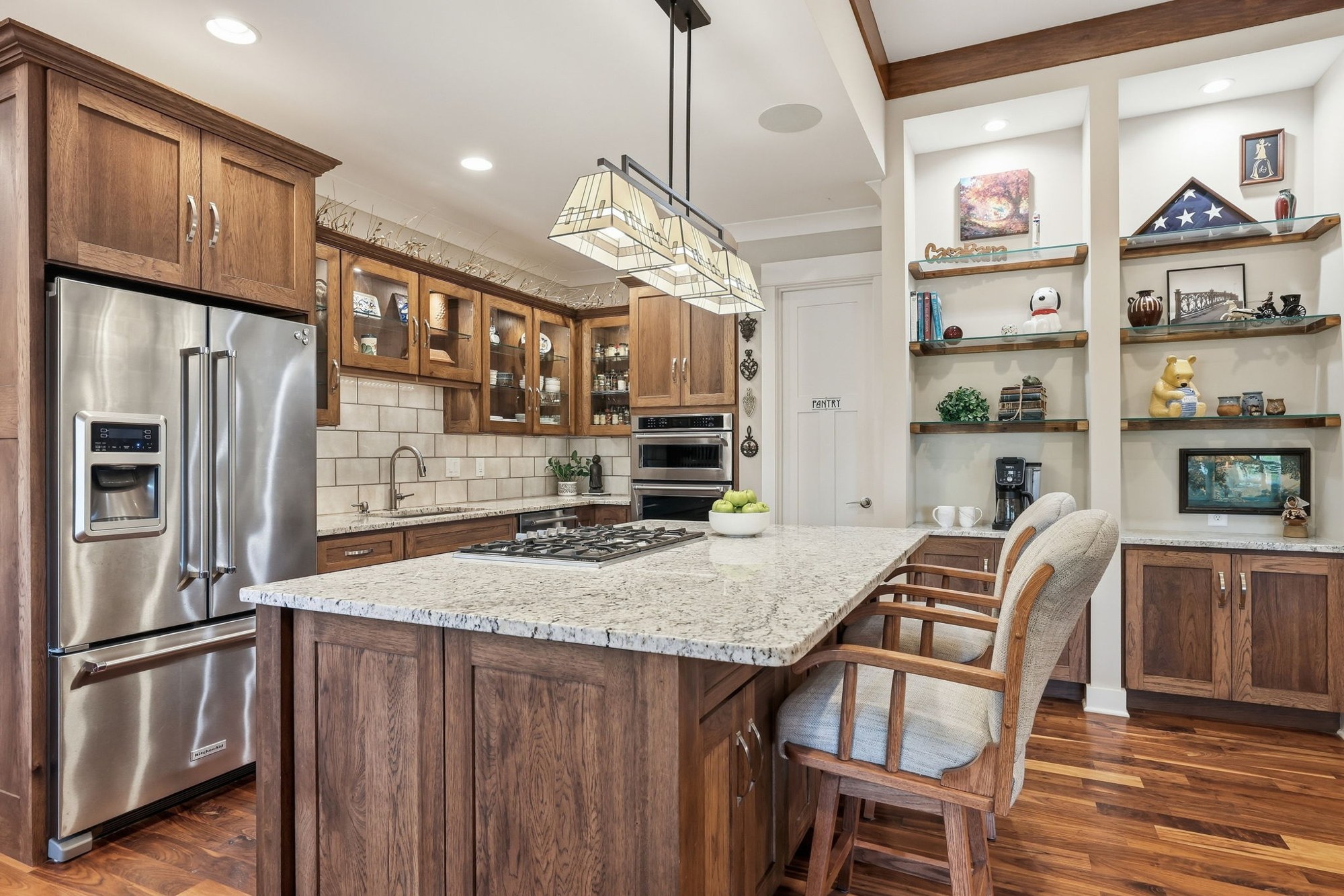 Warm wood kitchen with a stone island and detailed cabinetry