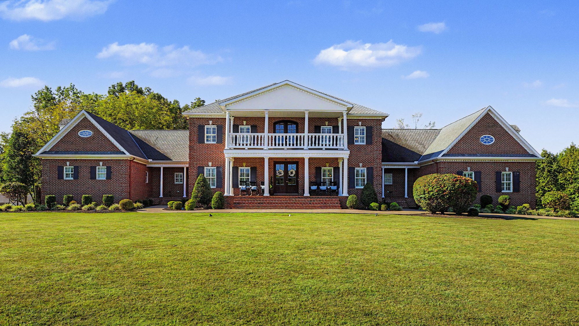 Brick home photographed by Real 3D Space, with a sweeping lawn and blue sky