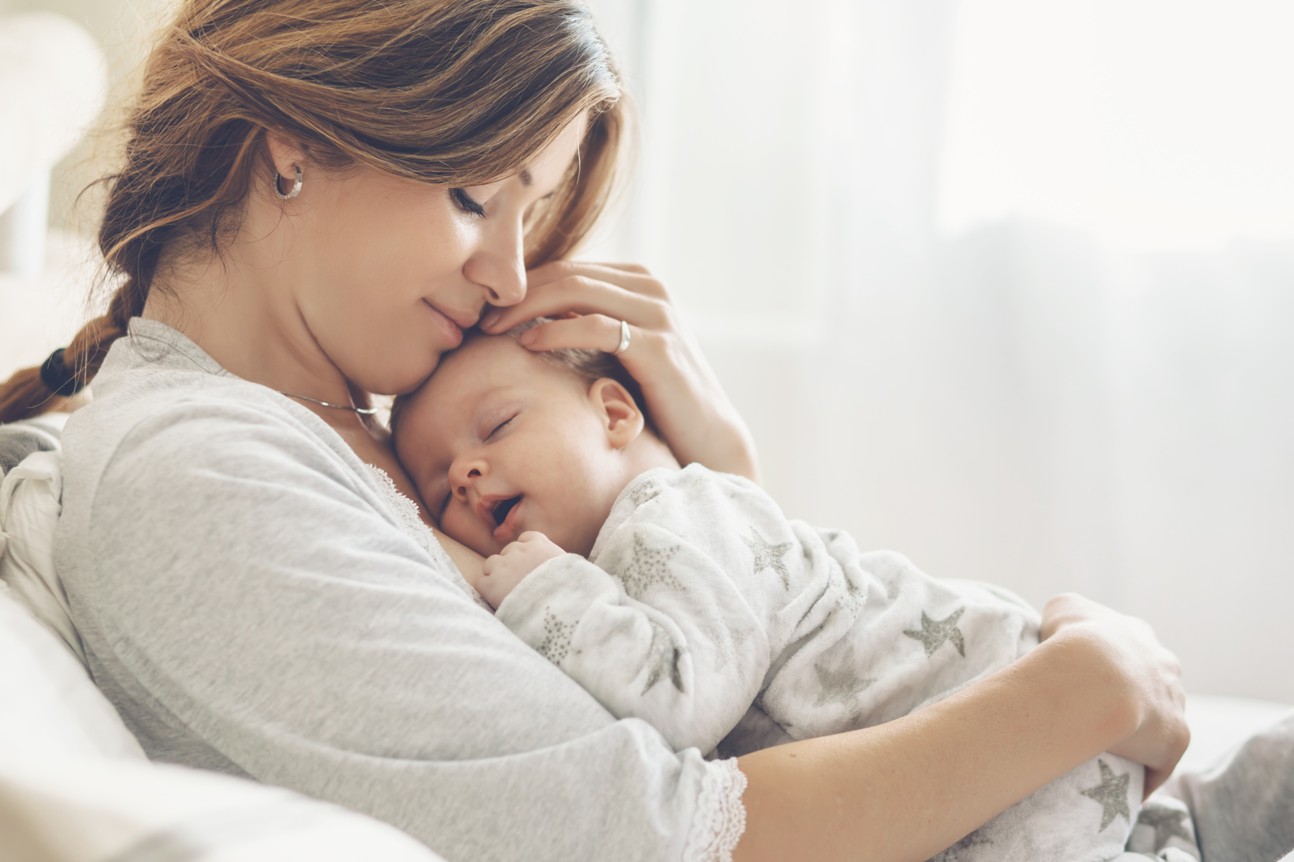 baby is cuddling with her mom