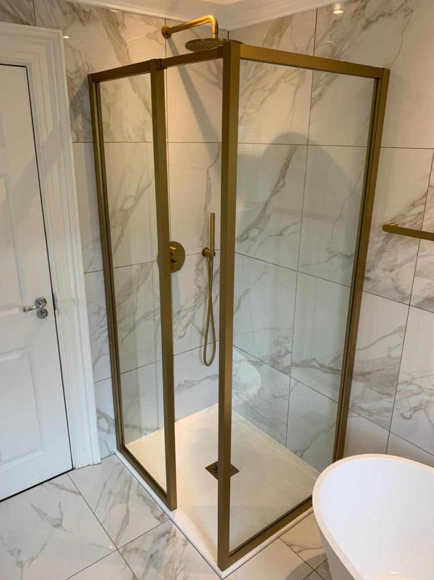 Marble shower enclosure with a brass frame