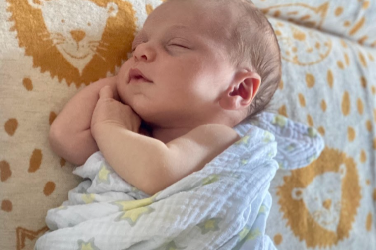 Newborn asleep in a muslin wrap