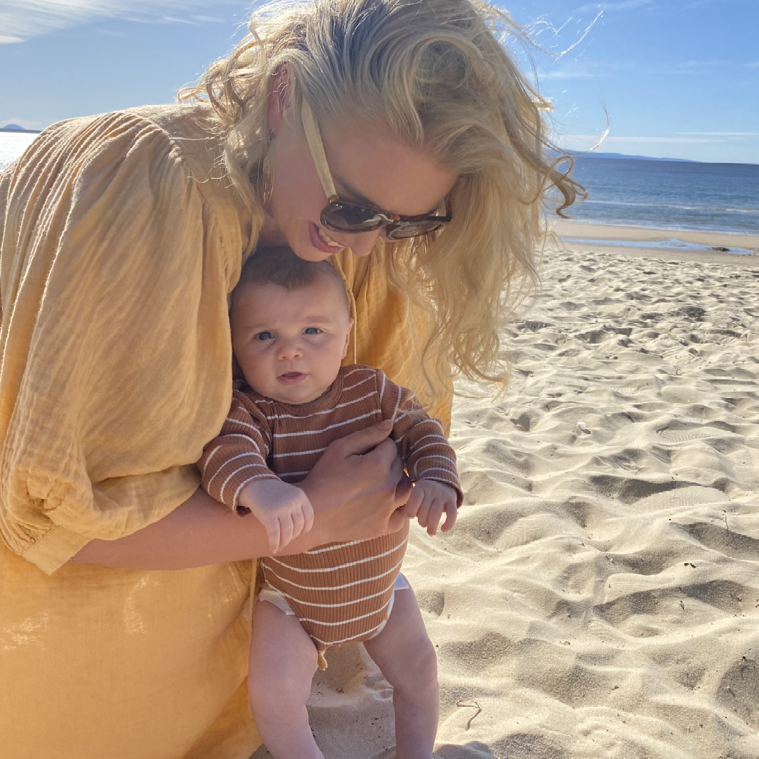 Mother holding her baby on the beach