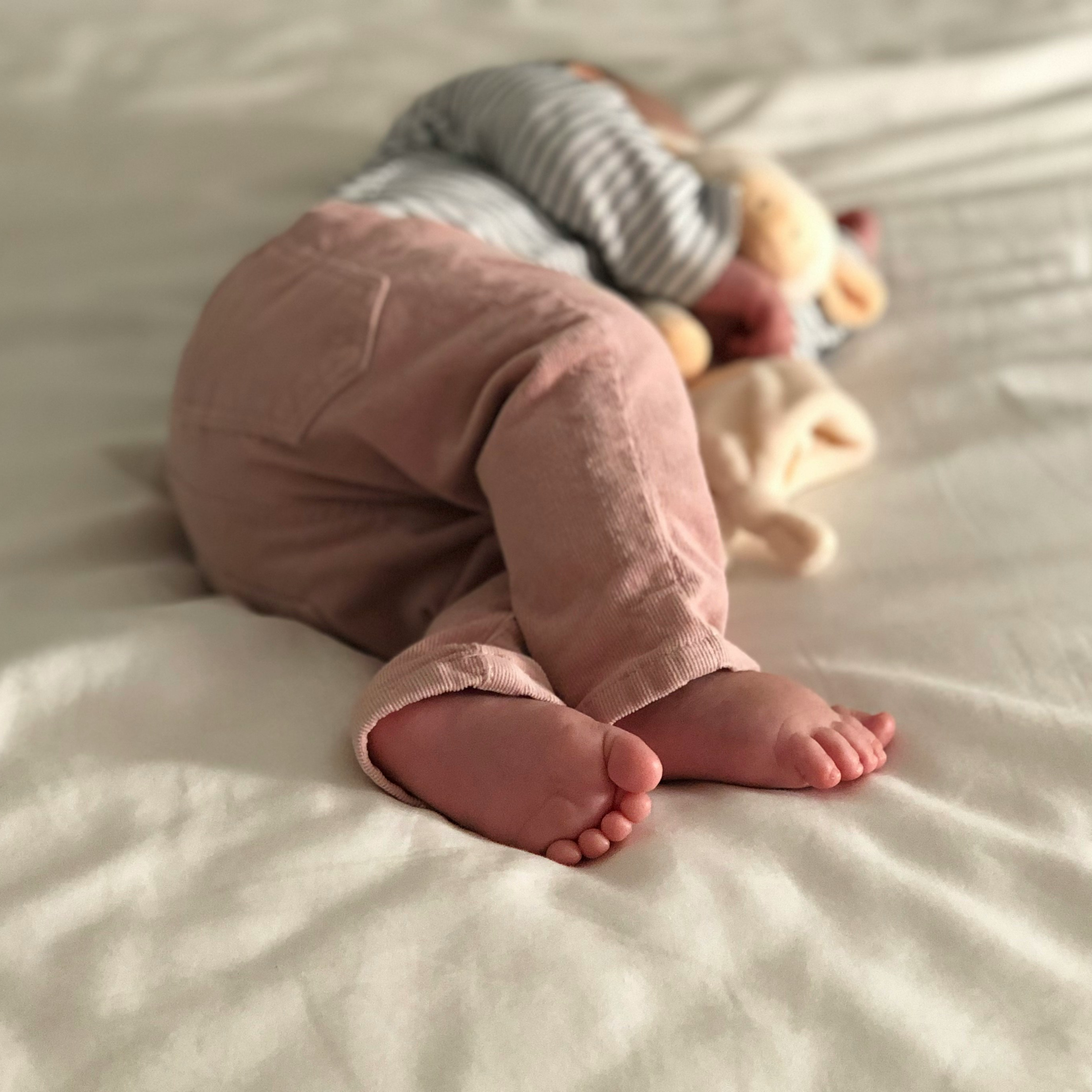 A baby asleep with a soft toy