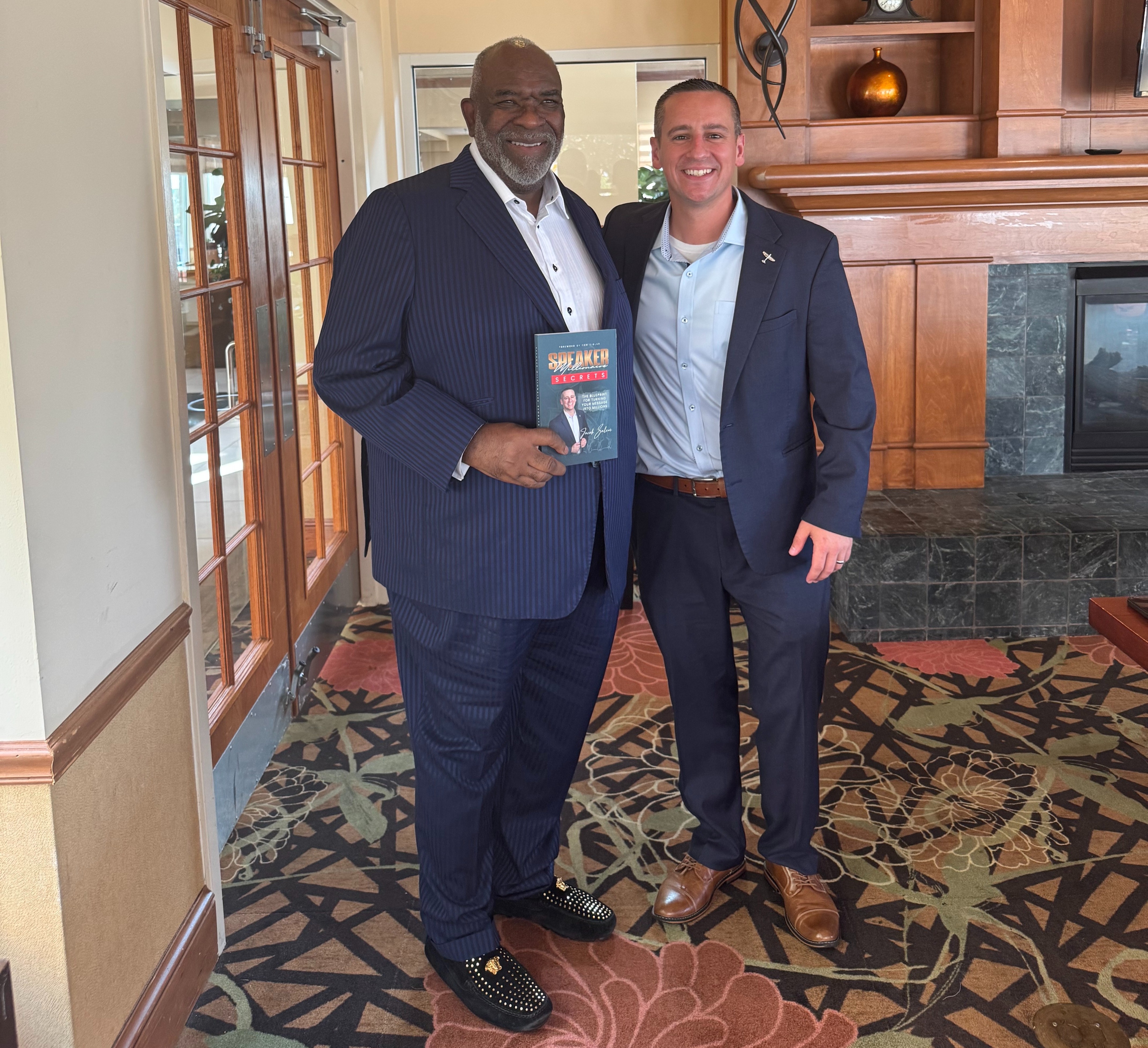 Sir Dr. James Dentley III holding Speaker Millionaire Secrets with Jacob Salem