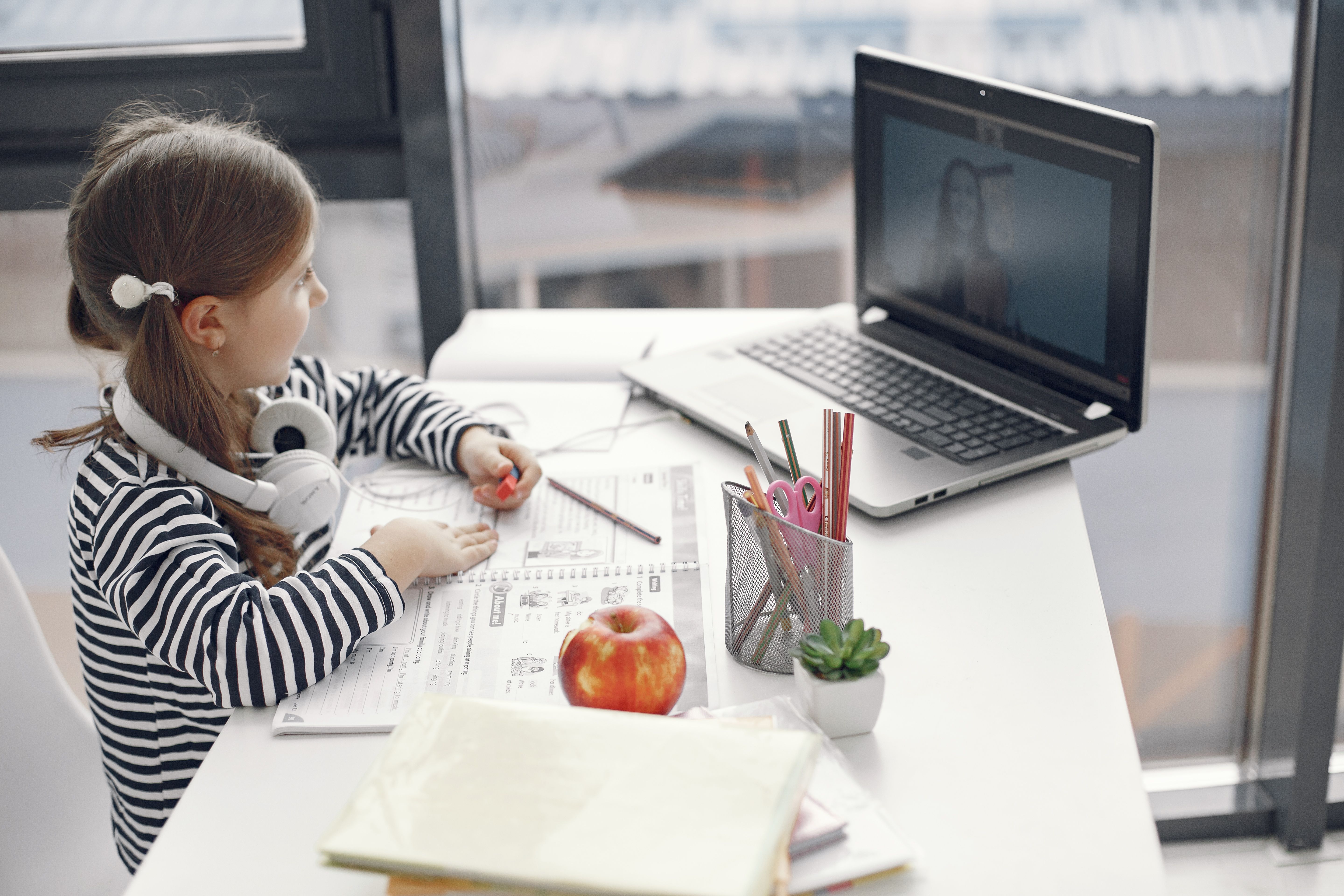 Young learner working at a desk beside a laptop