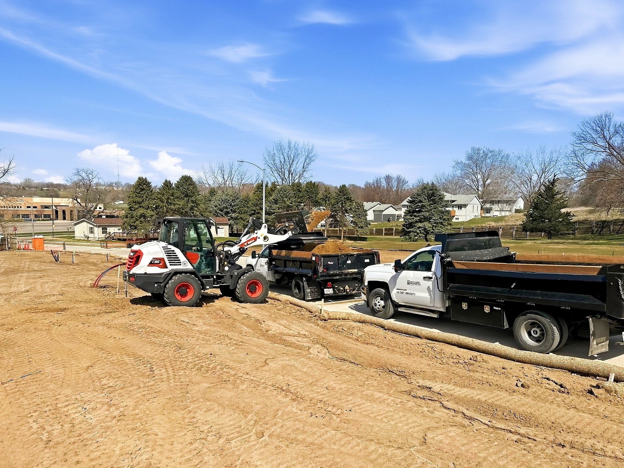 Bulldozer and dump truck doing site work in Sioux City, IA