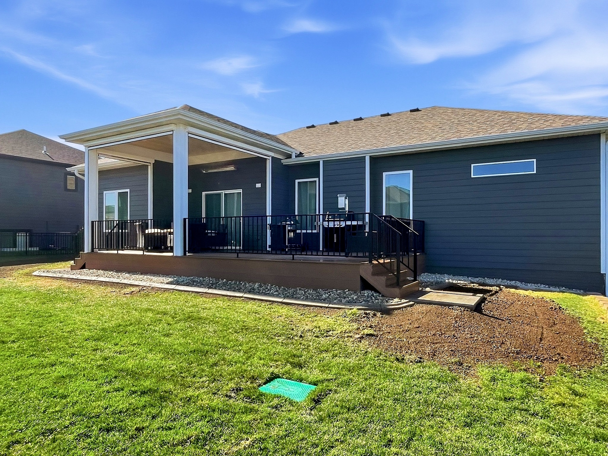Finished blue siding custom home with covered porch in Sioux City, IA